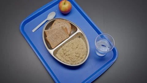 Basic Oatmeal and Bread Prison Rations Served on a Plastic Tray Stock Footage 231913836
