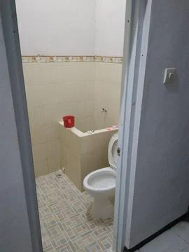 A basic residential bathroom interior features beige tiled walls and patterne Stock Photos