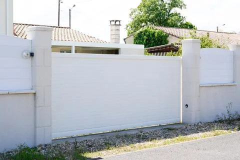 Basic simple white suburb metal aluminum house gate and slats street home Stock Photos