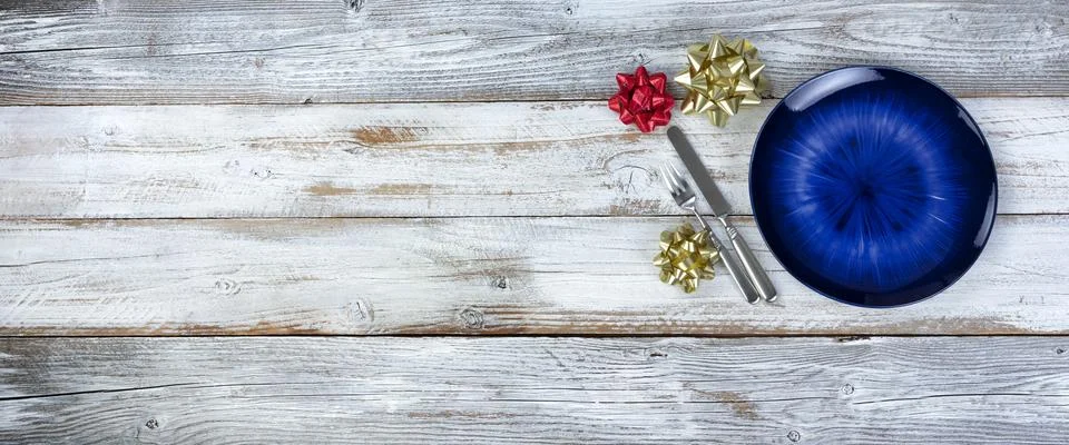 Basic table setting of an empty main dark blue dish with cutlery on wood Stock Photos