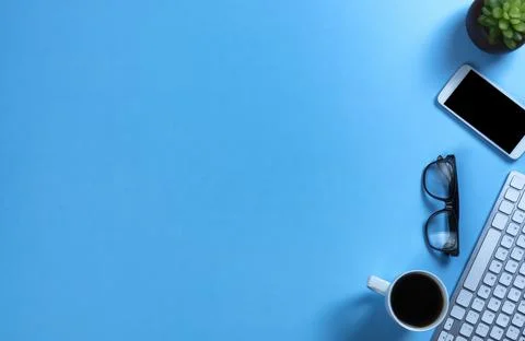 Basic work or school supplies with coffee on a blue desk top setting Stock Photos