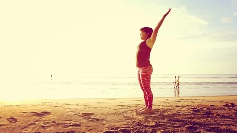 Basic Yoga of young Asian Thai woman on the beach during sunrise to re 스톡 동영상 78722999