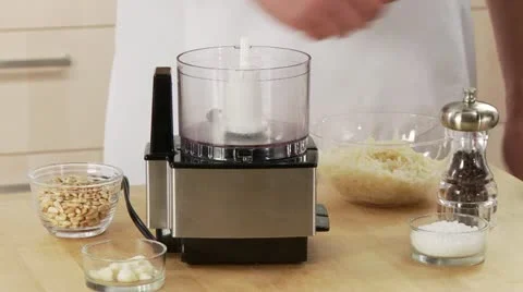 Basil and garlic being added to pesto ingredients in a mixer 스톡 동영상 24637116