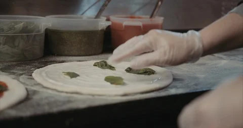 Basil leaves placed on a cream based pizza Stock Footage 105309259