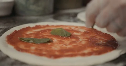 Basil leaves placed on red sauce pizza Stock Footage 105309274