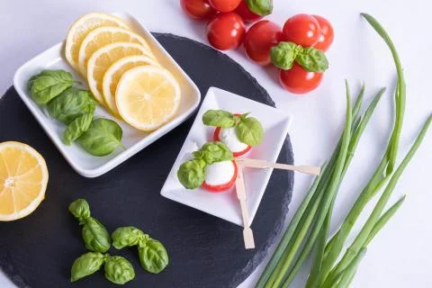Basil, mozzarella in red tomatoes and lemon Stock Photos
