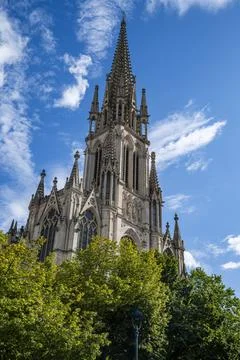 Basilica Saint-Epvre rises above trees under a clear blue sky in Nancy, France Stock Photos
