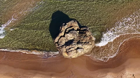 Bask in the beauty of a secluded beach where waves gently kiss the shore near a Stock Footage 331256658