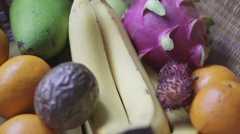 Basket with assorted fruit: mango, dragon fruit, passionfruit, banana, oranges Stock Footage 67675380