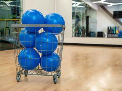 Basket with blue core exercise balls in an exercise studio with mirror Stock Photos