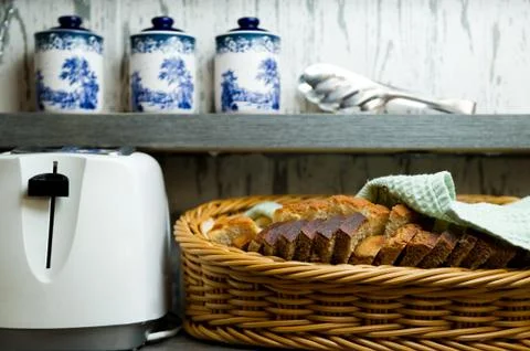 Basket with bread, toaster and jars Stock Photos