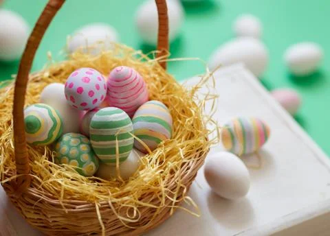 Basket with colorful Easter eggs, close up photo Stock Photos