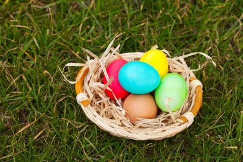 Basket with the colorful easter eggs Stock Photos