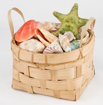 Basket with colorful shells on gray Foto stock