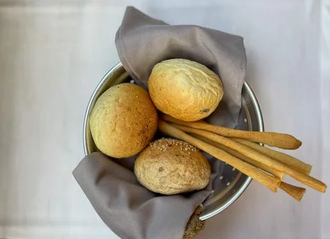 Basket with different types of fresh breads on the table. Stock Photos