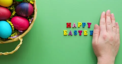 Basket with easter colored eggs and hand creating inscription happy easter Stock Footage 235770467
