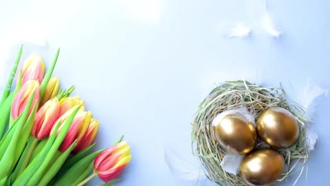 Basket easter decoration: Golden eggs in basket with spring tulips Stock Footage 147389410