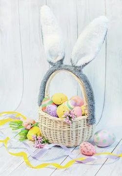 Basket with Easter eggs and decorative ears on a light background, Easter Stock Photos