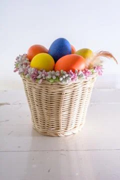 Basket with easter eggs and feathers Stock Photos