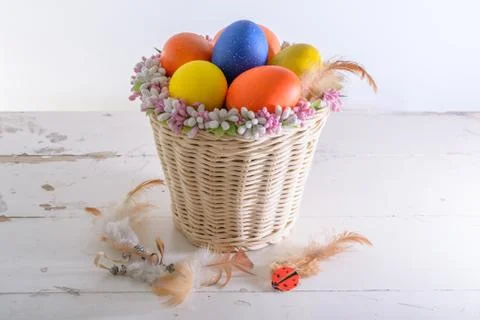 Basket with easter eggs and feathers Stock Photos