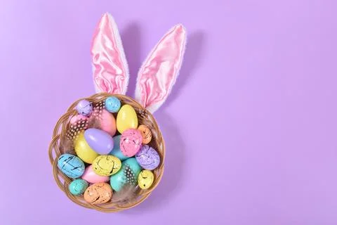 Basket with Easter eggs and rabbit ears in purple Foto stock