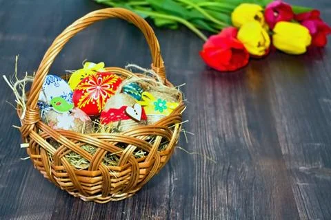 Basket with Easter eggs and tulip background. Stock-Fotos