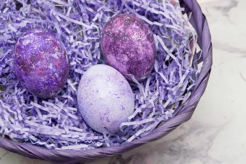 Basket with Easter eggs in color very peri on a marble background. Postcard plac Stock Photos