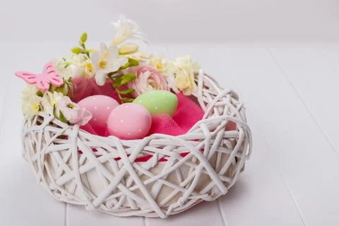 Basket of easter eggs with flowers Stock Photos