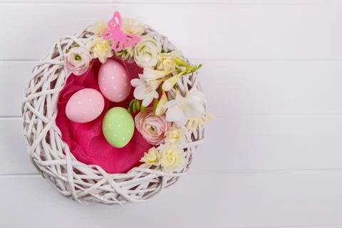 Basket of easter eggs with flowers Stock Photos