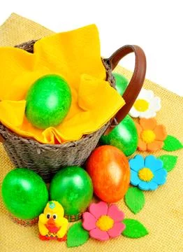 Basket with easter eggs, flowers on yellow napkin Stock Photos