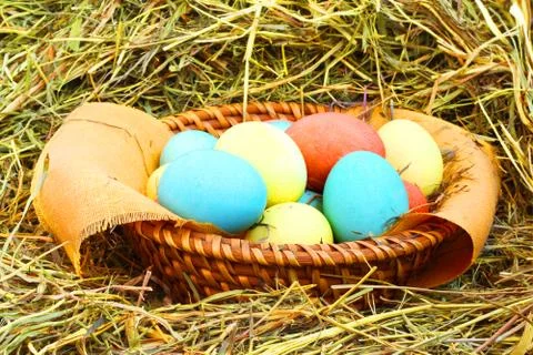 Basket of easter eggs on hay Stock Photos