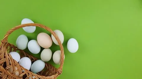 Basket with easter eggs of natural colors on a green background Stock Photos