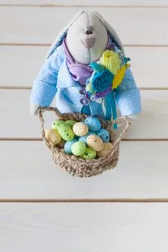 Basket with Easter eggs. Nest for eggs. Rabbit is a handmade toy. Stock Photos
