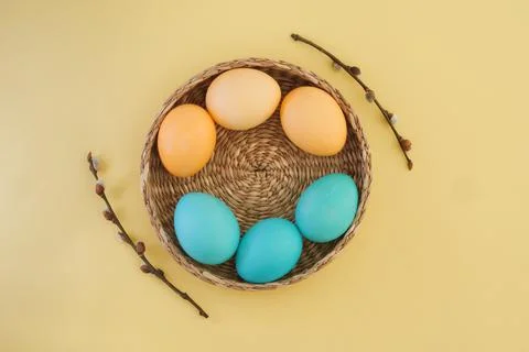 Basket with Easter eggs in pastel yellow and blue shades and pussy willow Stock Photos