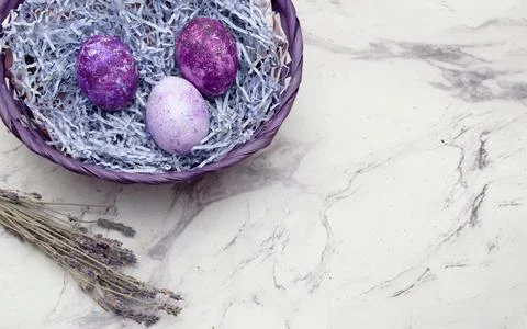 A basket with Easter eggs of a very beautiful color and a branch of lavender on  Stock Photos