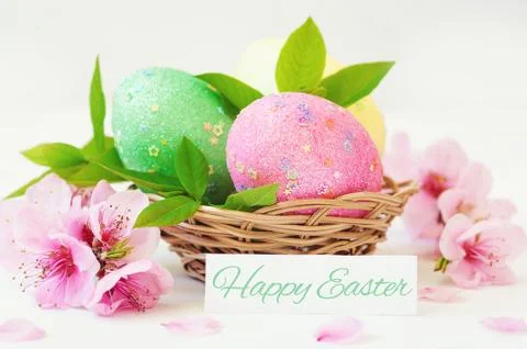 Basket with easter eggs on white background Stock Photos