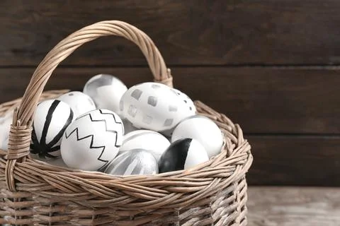 Basket of Easter eggs on wooden background, closeup. Space for text 스톡 사진