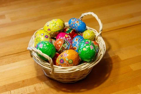 Basket with Easter eggs on wooden table Stock Photos