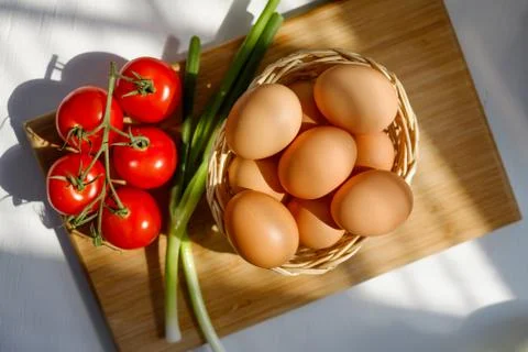 Basket of Eggs with a Bunch of Tomatoes Stock Photos