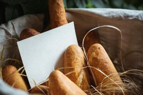 Basket filled with bread. Blank sheet of paper for the label. Stock Photos