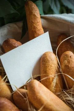 Basket filled with bread. Blank sheet of paper for the label. Stock Photos
