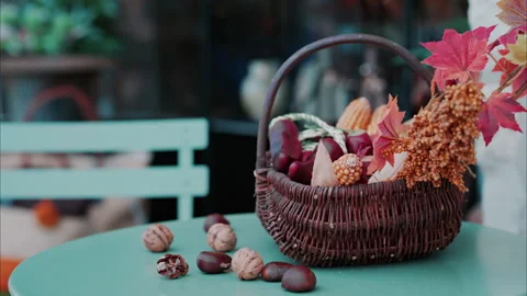 A basket filled with fall themed decor on a table at a terrace Stock Footage 290017412