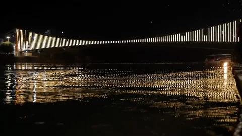 A basket of fire floats under a luminous bridge along the sacred river Ganges in Video stock 130100806