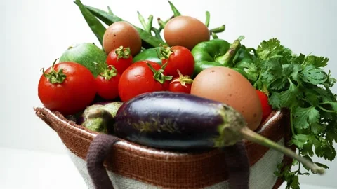 Basket of Fresh Vegetables and Eggs, A basket filled with fresh vegetables .. Stockbeeldmateriaal 305045581