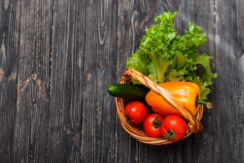 Basket with fresh vegetables on a rustic table. View from above Stock Photos