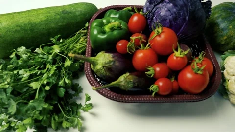 Basket of Fresh Vegetables on White Surface, A basket filled with fresh veg.. Stockbeeldmateriaal 305030053