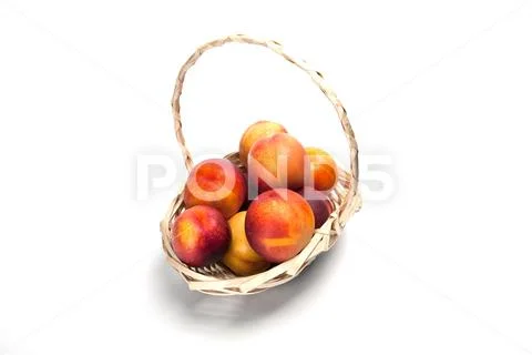 Basket full of fresh peaches isolated on white background Stock Photos