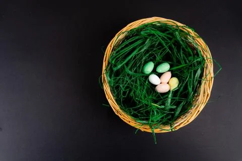 A basket full of grass and easter colorful easter eggs with copy space Stock Photos