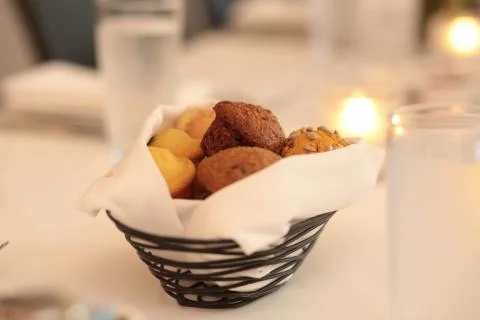 Basket of muffins on table, bread basket, restaurant, baked goods, candlelight,  Stock-Fotos