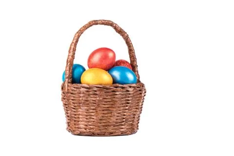 Basket with multi-colored Easter eggs isolated on a white background. Stock Photos